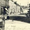 Na historické pohlednici z roku 1906 by v bílé kazajce vpravo mohl být před svou oficínou čistě hypoteticky holičský mistr Weger osobně 